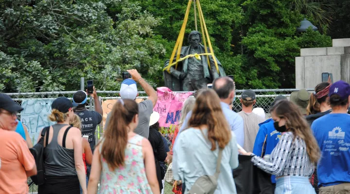 People rush to see the face of John C. Calhoun as the statue is taken down after more than 124 years.  June 24, 2020