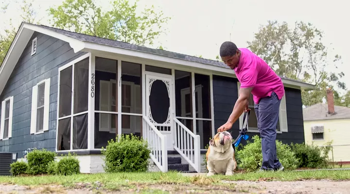 James Wilder takes his dog for a walk outside his home in Charleston, SC.