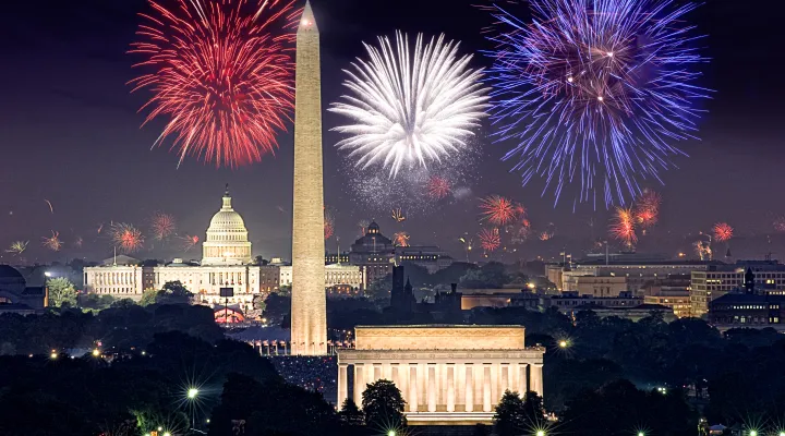 photo of fireworks above illuminated monuments in Washington, D.C.