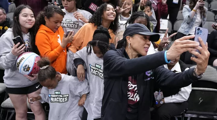South Carolina head coach Dawn Staley takes a selfie with fans after a practice session for an NCAA Women's Final Four semifinals basketball game Thursday, March 30, 2023, in Dallas. (AP Photo/Tony Gutierrez)