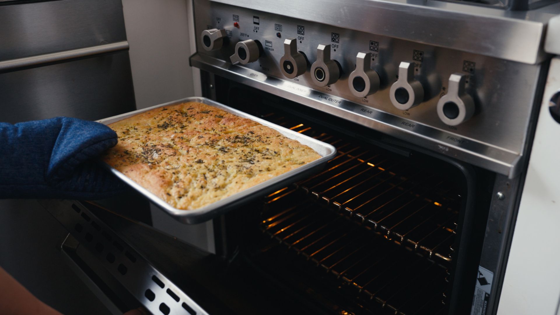 Chef Lauren Furey taking focaccia bread from oven