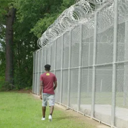 Turn90 program participant walking outside prison walls