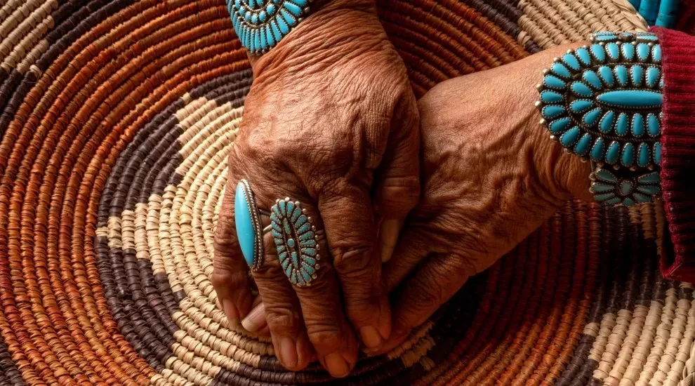 image of native american hands wearing tribal jewelry on tribal print