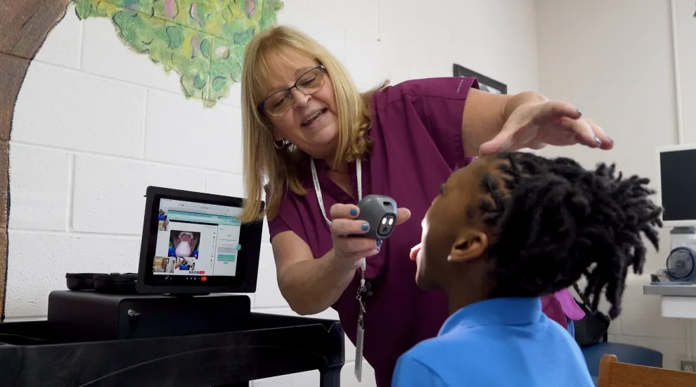 Telepresenter Lorrie Smart conducts a telehealth visit with Zaire at his school in Pinewood, South Carolina. 