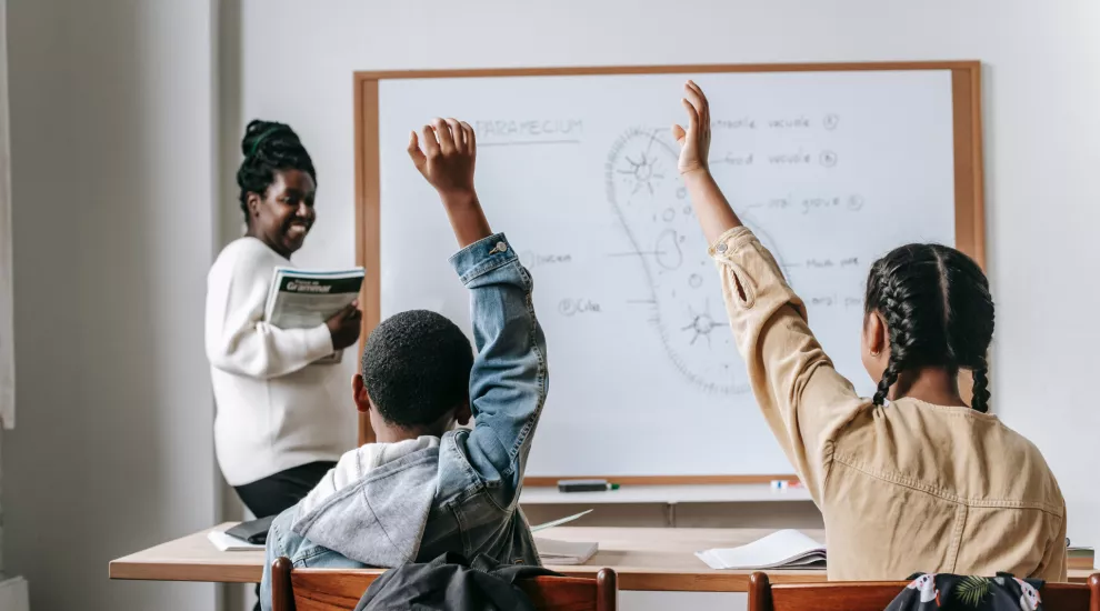 photo of teacher with 2 students in classroom