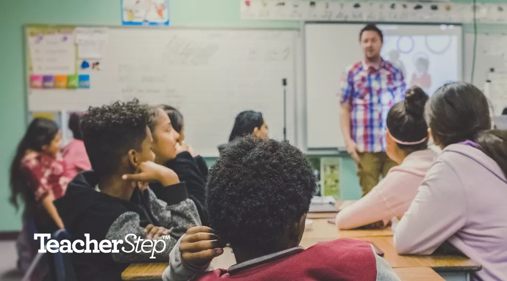 photo of male teacher in front of class students