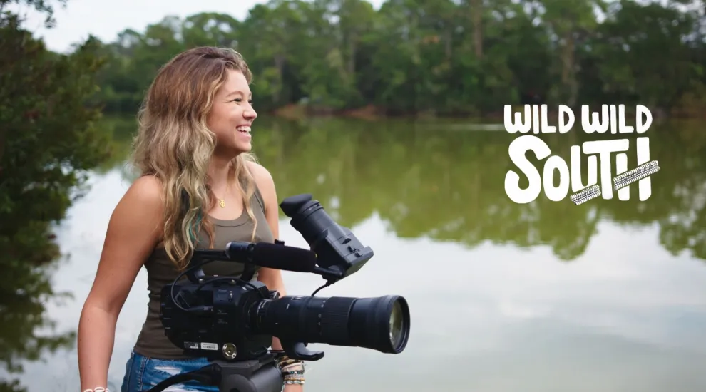 image of host hyatt holding camera in marsh with series logo in background