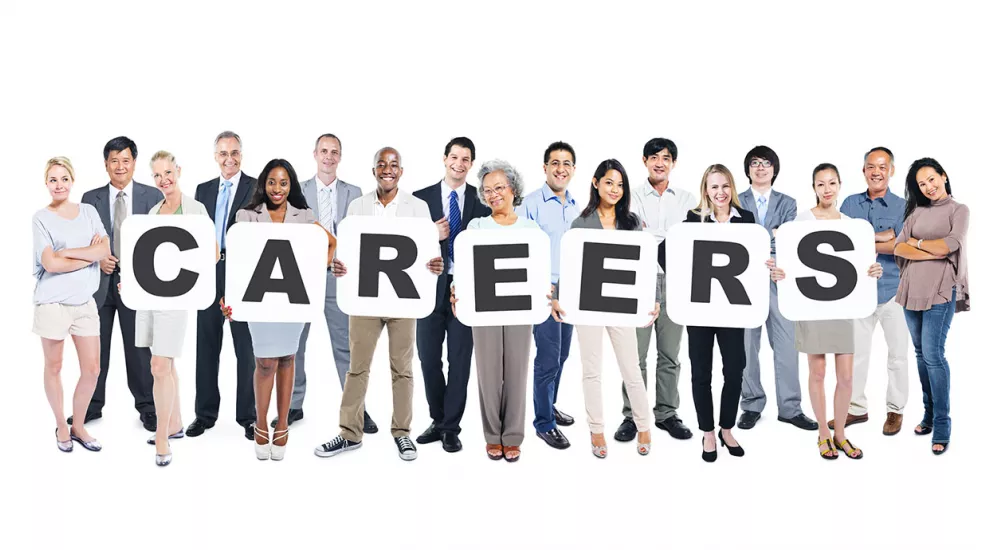 A group of diverse people holding cards that spell the word "Careers"