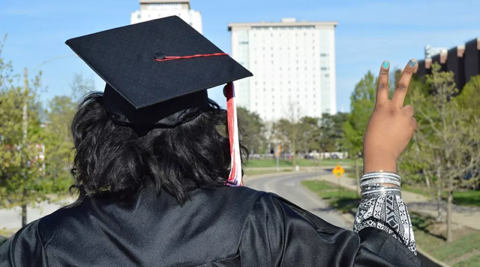 Carolina Classrooms image of graduate making peace sign