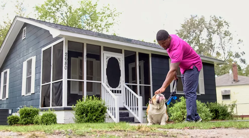 James Wilder takes his dog for a walk outside his home in Charleston, SC.