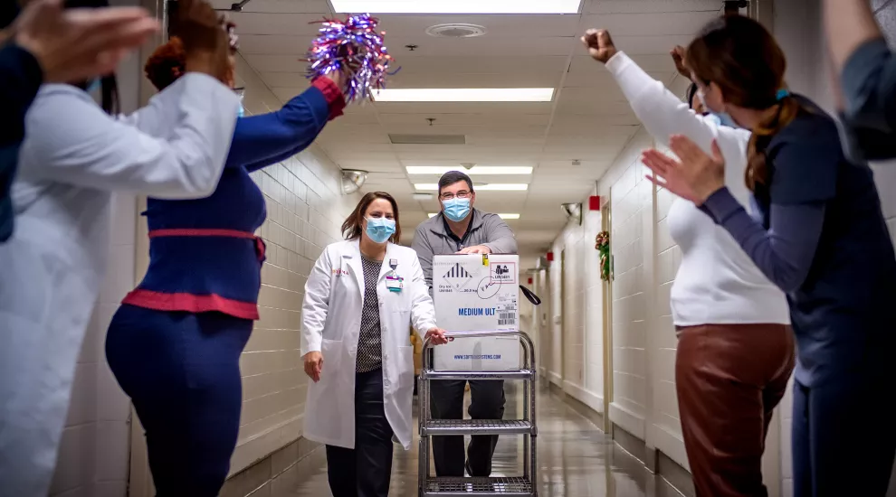 Prisma Health staff cheer as healthcare workers transport the Pfizer BioNTech vaccine in the Columbia hospital on December 15, 2020.