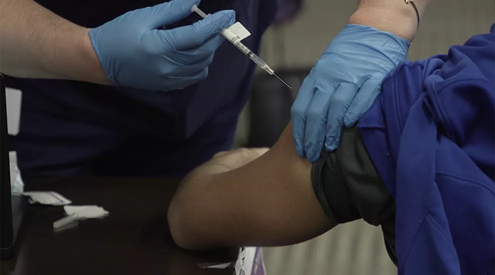 A patient receives the COVID-19 vaccine from a medical professional at a Roper St. Francis Healthcare clinic.