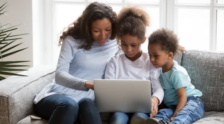 Mother reading on sofa with two children