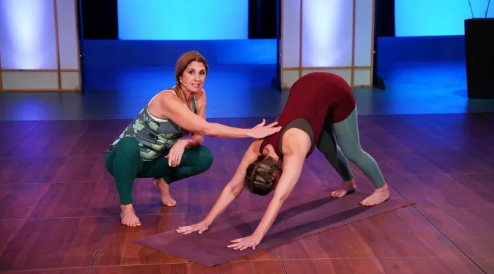 Yoga instructor Stacey Millner-Collins with student doing downward facing dog