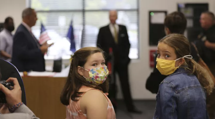 Two Camden Elementary School students in masks listen as South Carolina Gov. Henry McMaster talks about steps the school is taking to fight COVID-19, Wednesday, Sept. 15, 2021, in Camden, S.C. McMaster has adamantly and repeatedly come out against requiring masks in schools even as the average number of daily COVID-19 cases in the state has risen since early June. (AP Photo/Jeffrey Collins)